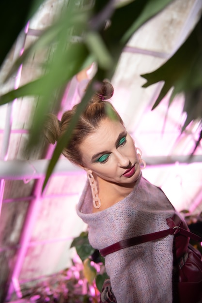 Such a beauty. Pleasant nice woman having a beautiful makeup while posing in the greenhouse