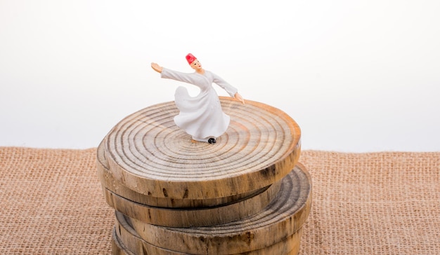 Photo sufi dervish figurine model in small size on wooden log pieces