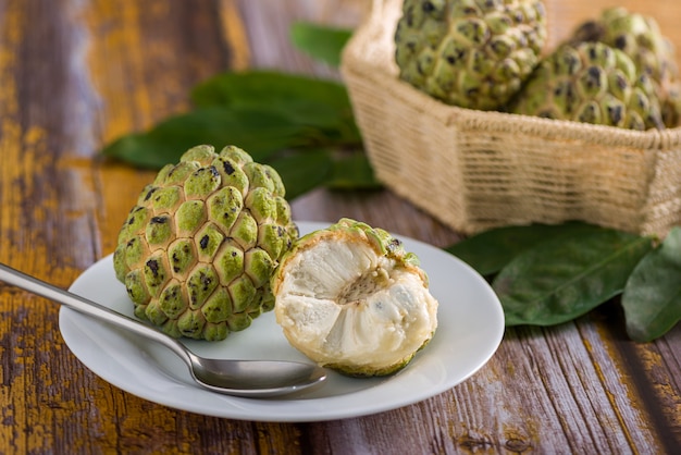 Sugar apple on a white plate with stainless steel spoon ready to be eaten In addition to other sug