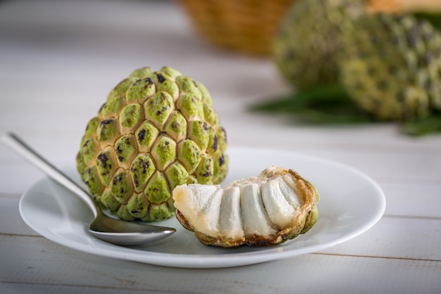 sugar apple on a white plate with stainless steel spoon ready to be eaten