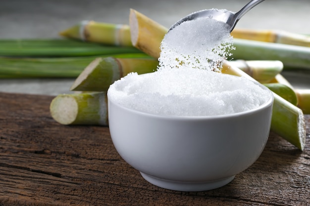 Sugar being poured from spoon into a bowl Empty ready for your product display or montage