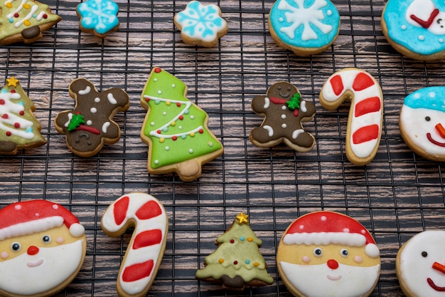 Sugar coated biscuits and Christmas theme cookies on a baking rack with Christmas ornaments.