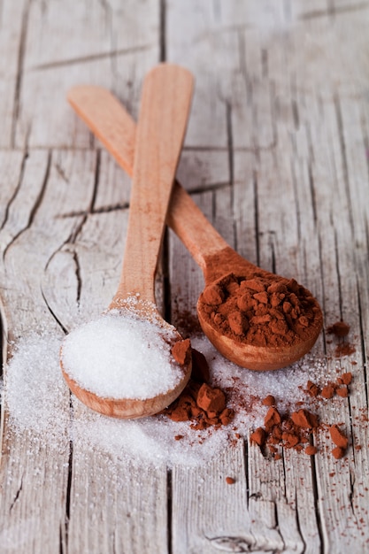 Sugar and cocoa powder in spoons 