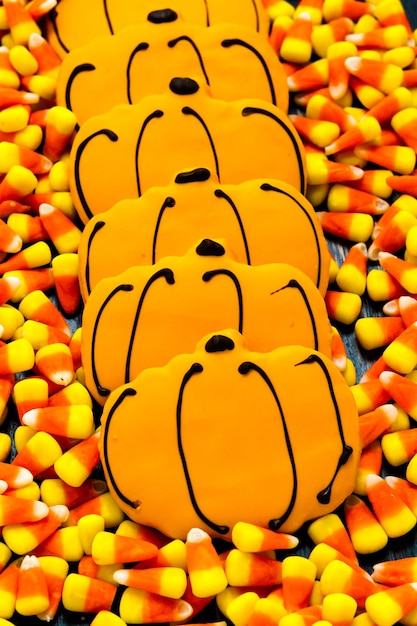 Sugar cookies with orange icing shaped like a pumpkin.