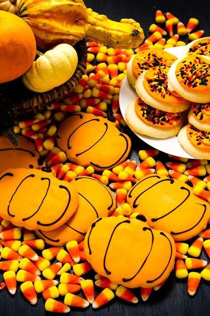 Sugar cookies with orange icing shaped like a pumpkin.