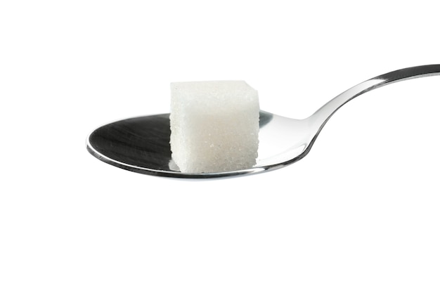 Sugar cube in spoon on white