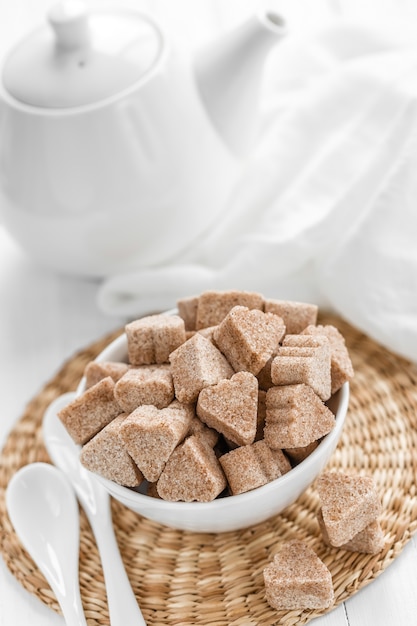 Sugar cubes in a bowl on wooden table