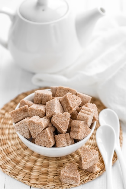 Sugar cubes in a bowl on wooden table