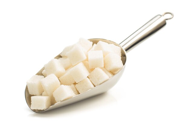 Sugar cubes in scoop isolated on white