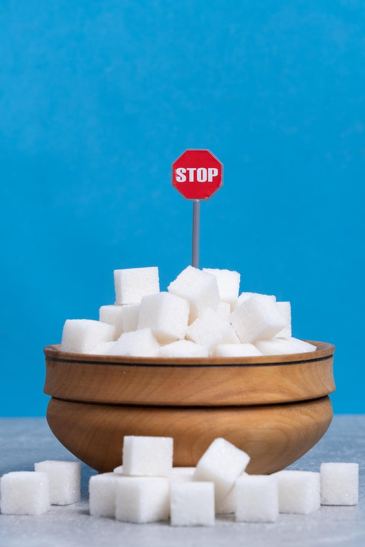 Photo sugar cubes in wooden bowl with stop sign on blue background