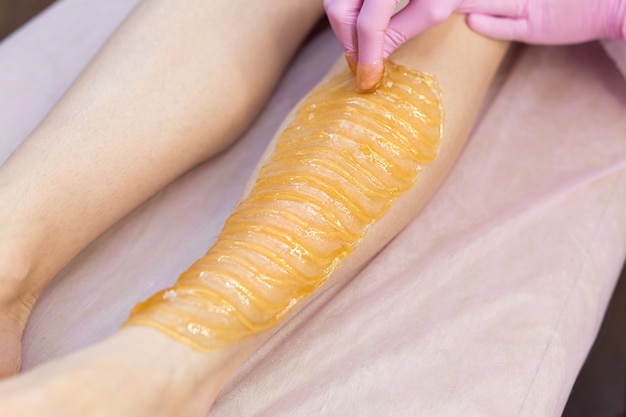 Sugar depilation of the feet in the beauty salon