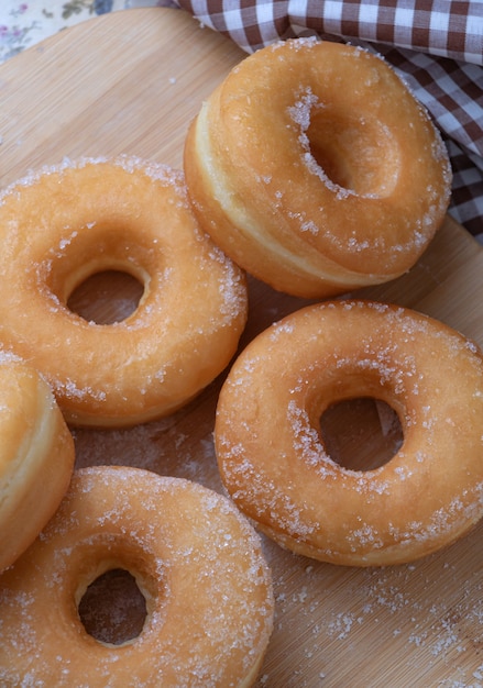 Sugar donuts on wooden board