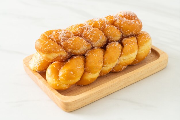 sugar doughnut in spiral shape on wooden plate