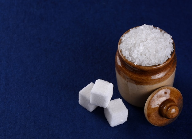 Foto zucchero. zucchero semolato bianco e zucchero raffinato su sfondo blu