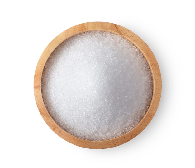 Sugar in wood bowl on white wall.