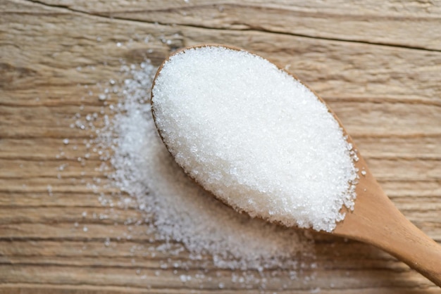 Sugar on wooden spoon background white sugar for food and sweets dessert candy heap of sweet sugar crystalline granulated