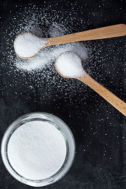 Photo sugar in wooden spoons and glass jar