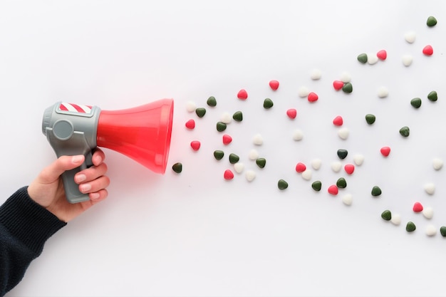 SugarCoated HeartShaped Sweets Flying Out of egaphone Propaganda Concept plat gelegd