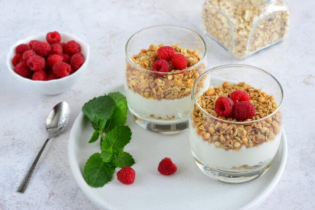 sugarfree dessert with yogurt granola and raspberries in drinking glass