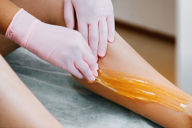 Sugaring Sugar waxing feet in the beauty salon.