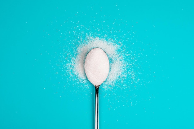 Sugarreplacing tablets with a spoon on a blue background