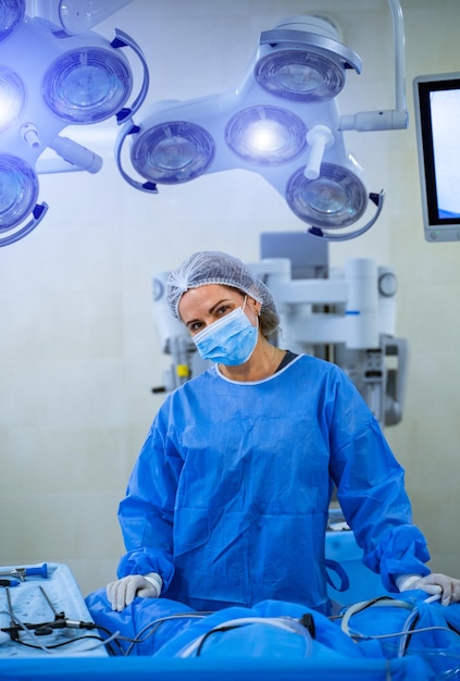 Sugeon woman wearing surgical gear in a surgical room modern\
operation theatre with bright lights close up