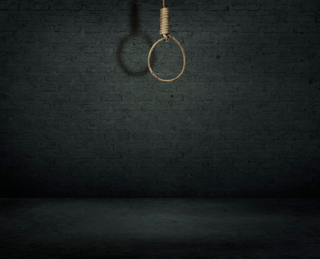 Suicide concept noose with shadow on dark wall background