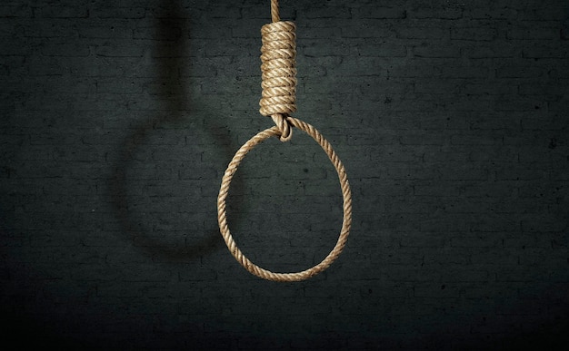 Suicide concept noose with shadow on dark wall background