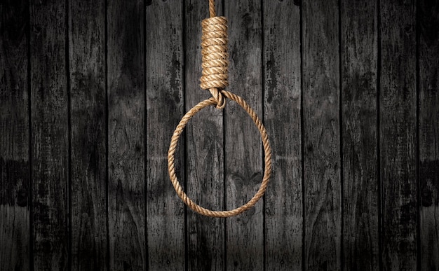 Suicide concept noose with shadow on dark wall background