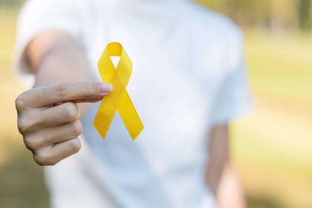 Prevenzione del suicidio, sarcoma, ossa, vescica, mese di sensibilizzazione sul cancro infantile, nastro giallo per sostenere le persone che vivono e le malattie. concetto di salute dei bambini e giornata mondiale del cancro