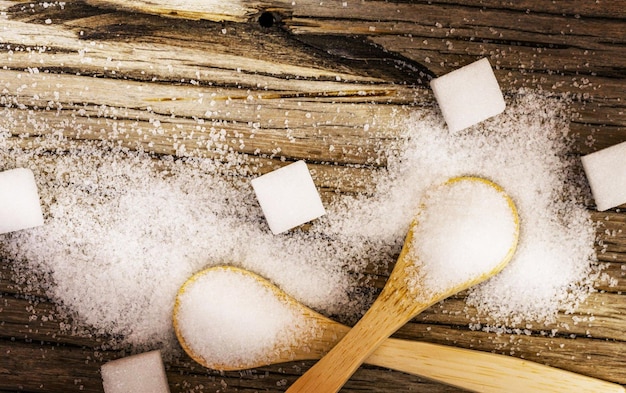 Foto suiker en houten lepels op een houten tafel