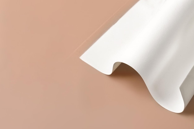 Suiker leeg wit vel papier gebogen voor taartkleurendruk op beige achtergrond