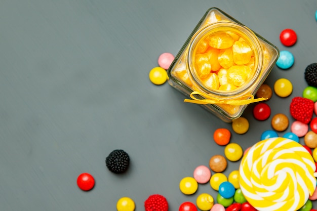 Suikergoed met verschillende vormen en kleuren op een grijze houten achtergrond. Zachte focus