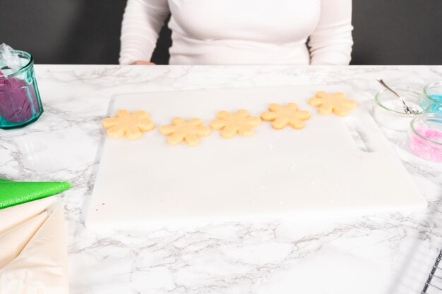 Suikerkerstkoekjes versieren met royal icing en hagelslag.