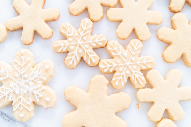 Suikerkerstkoekjes versieren met royal icing en hagelslag.