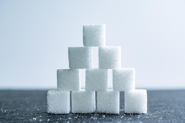 Suikerklontjes op witte achtergrond Suiker is ongezonde voeding en leidt tot obesitas diabetes tandheelkundige zorg