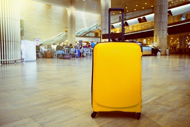 Suitcase in airport airport terminal waiting area with lounge zone as a background. Vacation theme concept