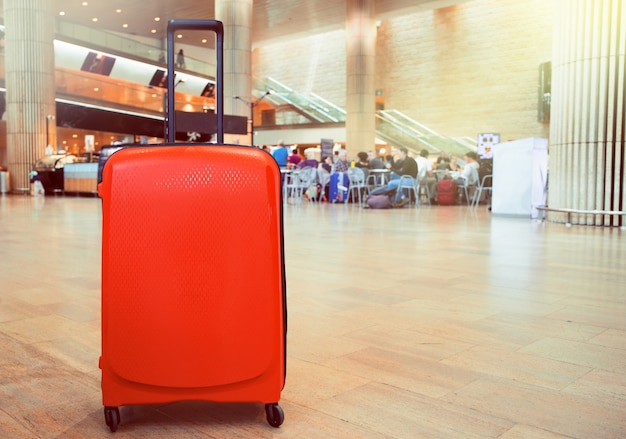 Suitcase in airport terminal waiting area. Traveling luggage in airport terminal. 