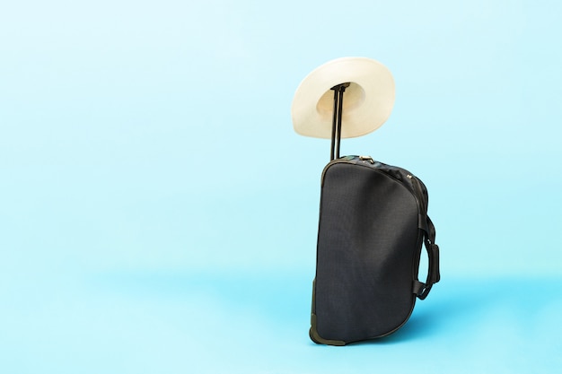 Photo suitcase and hat on a blue background.