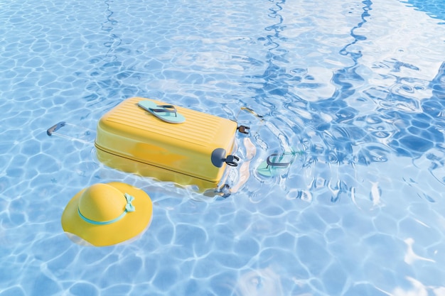 Suitcase and hat floating in water