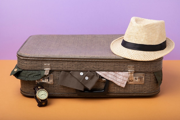 Photo suitcase for travel filled with clothes and straw hat