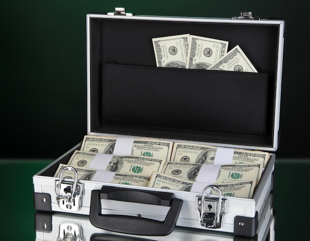 Suitcase with 100 dollar bills isolated on black