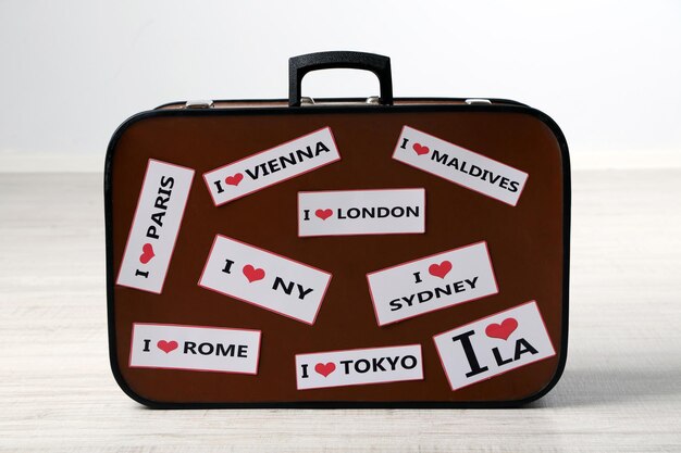 Photo suitcase with stickers on floor in room