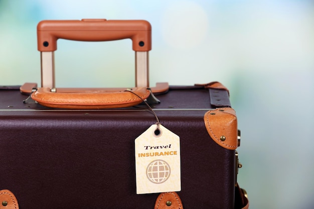 사진 밝은 배경에 travel insurance 레이블이 있는 가방