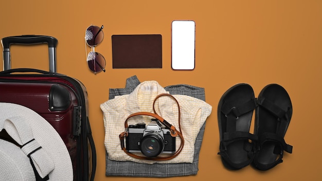 Suitcase with traveler accessories on white orange background Packing for a new journey