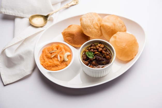 Suji or Sooji Halwa Puri or Sheera or Shira Poori breakfast, served in a plate and bowl. selective focus