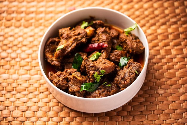 Photo sukha mutton or chicken dry spicy murgh or goat meat served in a plate or bowl