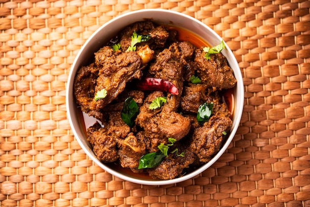 Photo sukha mutton or chicken dry spicy murgh or goat meat served in a plate or bowl