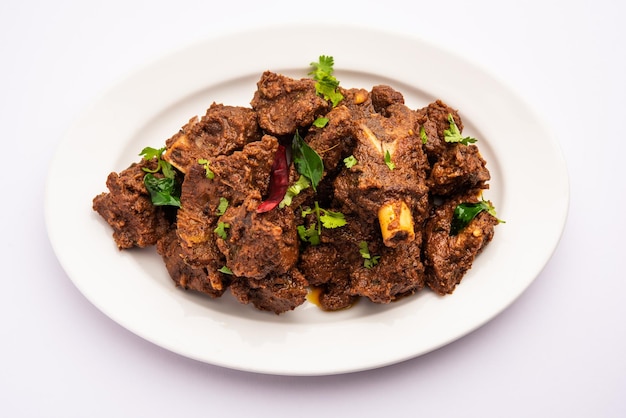 Photo sukha mutton or chicken dry spicy murgh or goat meat served in a plate or bowl