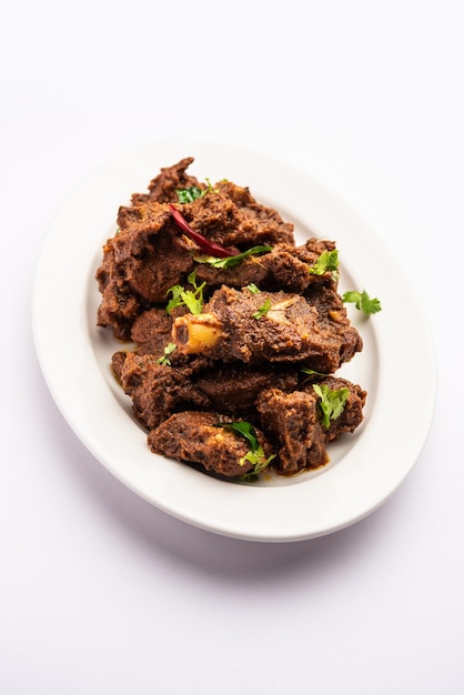 Photo sukha mutton or chicken dry spicy murgh or goat meat served in a plate or bowl